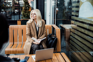 Attractive middle-aged lady relaxing in a cafe