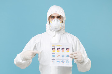 Man in white protective suit respirator mask hold card with symptom contagion prevention isolated on blue background studio. Epidemic rapidly spreading coronavirus 2019-ncov medicine flu virus concept