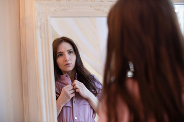 young girl dresses in the morning at the mirror