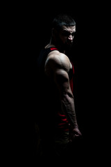 Fototapeta na wymiar Muscular Man Flexing Muscles on Black Background
