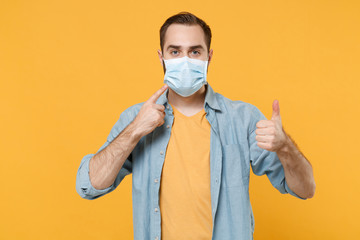 Young man in casual clothes posing isolated on yellow background. Epidemic pandemic coronavirus...