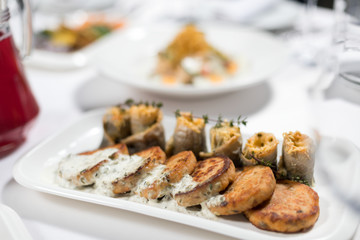 Seafood. Fish cakes and cheese rolls stuffed with fish fillet on a plate on a white background