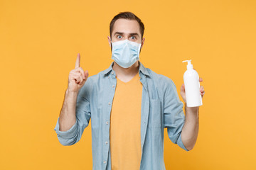 Excited man in face mask isolated on yellow background. Epidemic pandemic coronavirus 2019-ncov...