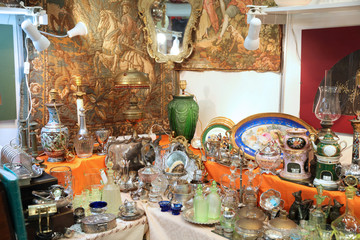 Vintage shop with a lot of beautiful vintage tableware items made of glass, metal and ceramics