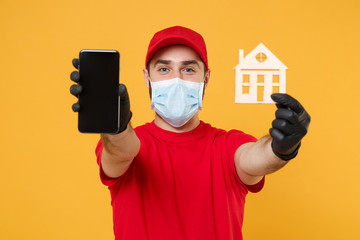 Fototapeta na wymiar Delivery man in red cap blank t-shirt uniform sterile face mask gloves isolated on yellow background studio Guy courier hold mobile cell phone Service quarantine pandemic coronavirus 2019-ncov concept