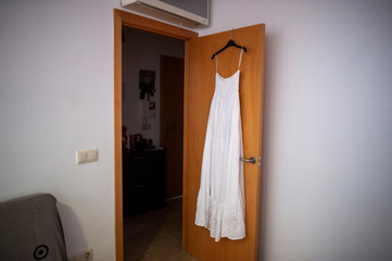 Fototapeta na wymiar Wedding dress hanging on a wooden door