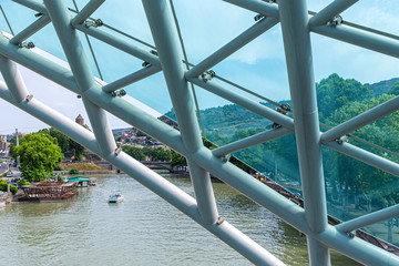 Old Tbilisi and the Kura river through the glazed metal structures of the bridge of Peace