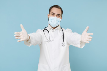 Male doctor man in white medical gown sterile face mask gloves isolated on blue background....