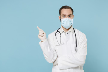 Male doctor man in white medical gown sterile face mask gloves isolated on blue background....