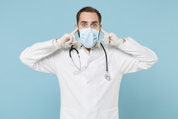 Male doctor man in white medical gown sterile face mask gloves isolated on blue background....