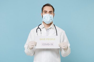 Male doctor man in medical gown face mask gloves isolated on blue background. Epidemic pandemic...
