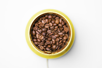 Yellow coffee grinder with coffee and beans, top view
