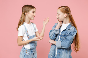 Excited little kids girls 12-13 years old in white t-shirt, denim clothes isolated on pink...
