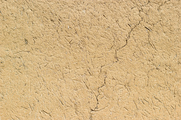 Adobe - clay and straw material weathered wall of rural old country house close-up as clay background