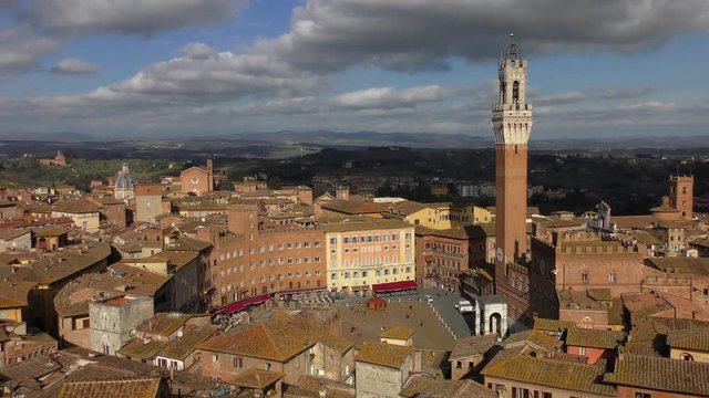 Aerial view of the Tower of Torre del Mangia (literally - Tower of the Devourer) on the Piazza del Campo. Siena, Italy. Warm sunny winter day.