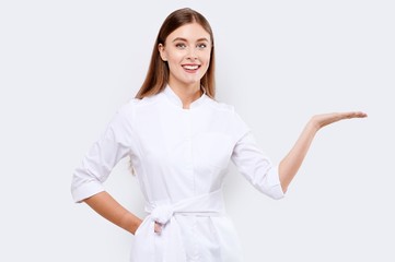 Young female doctor holding something on white isolated background. Corona Virus covid19 Pandemic concept