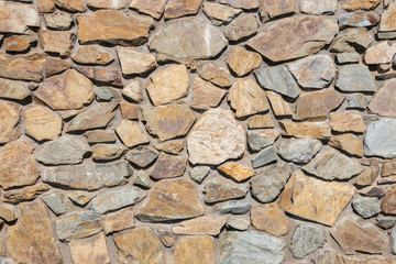 detail of sunlit brown and grey natural stone pavement