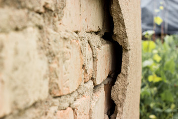 Non technology plaster. Building cracked plaster facade wall with brick.