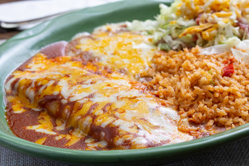 A view of a plate of enchiladas in a restaurant or kitchen setting.
