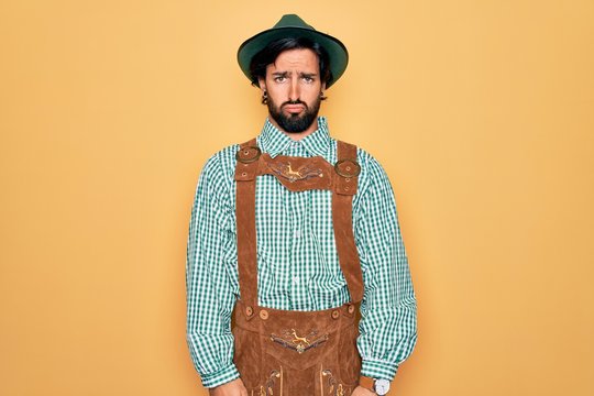 Young handsome man wearing tratidional german octoberfest custome for Germany festival depressed and worry for distress, crying angry and afraid. Sad expression.