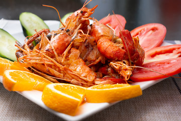 A closeup view of a plate of langoustines, in a restaurant or kitchen setting.