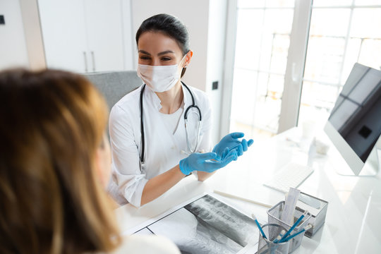 Young Clever Pediatrician In Medical Mask Talking To Patient