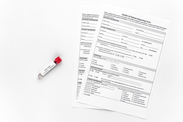 Obraz premium Test tube with blood test for coronavirus 2019-nCov. Patient's form with covid-19 test results. An outbreak of respiratory diseases. SARS.