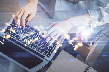 Double exposure of woman hands typing on computer and forex chart hologram drawing. Stock market invest concept.