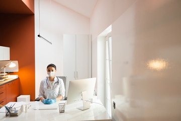 Caucasian doctor in medical mask and rubber gloves looking at camera