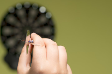 Hand holding a dart preparing to hit the target. Concept of value and success of entrepreneurs
