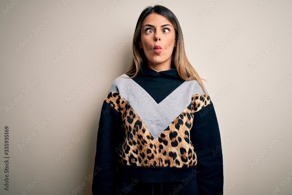 Sticker young beautiful woman wearing casual sweatshirt standing over isolated white background making fish 