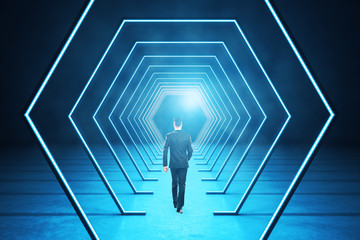 businessman walking in modern blue interior with abstract luminous hexagon corridor.