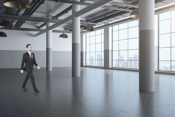 Fototapeta premium Businessman walking in hall with columns