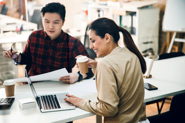 Cheerful lady working with male colleague in office