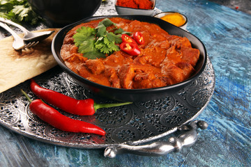Chicken tikka masala spicy curry meat food in pot with rice and naan bread. indian food on table