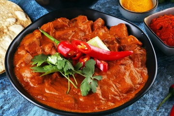 Chicken tikka masala spicy curry meat food in pot with rice and naan bread. indian food on table
