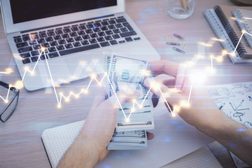 Multi exposure of financial graph drawing hologram and USA dollars bills and man hands. Analysis concept.