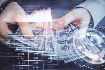 Multi exposure of financial graph drawing hologram and USA dollars bills and man hands. Analysis concept.