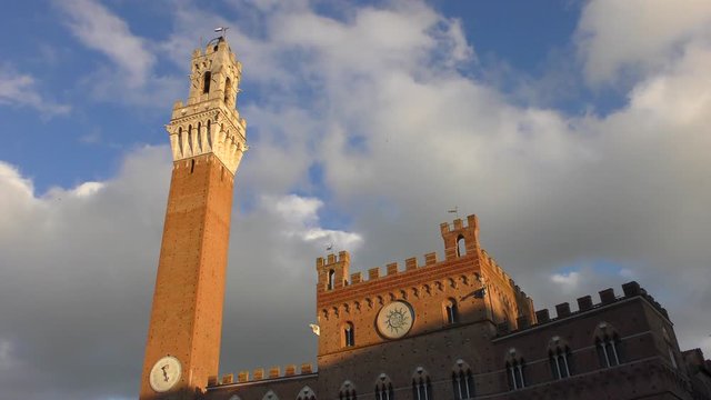 Tower of Torre del Mangia (literally - Tower of the Devourer) on the Piazza del Campo. Siena, Italy. Warm sunny winter day.