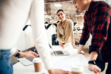 Cheerful young woman working with colleagues in office