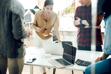 Obraz premium Office workers using laptops and drinking coffee