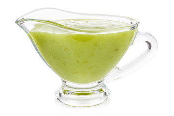Green chili sauce with lime in a transparent glass gravy boat isolated on white background