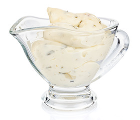 Tartar sauce with onions and pickled cucumbers in a transparent glass gravy boat isolated on white background