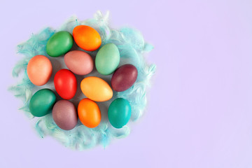 Kolorowe pisanki otoczone niebieskimi piórami © Monika