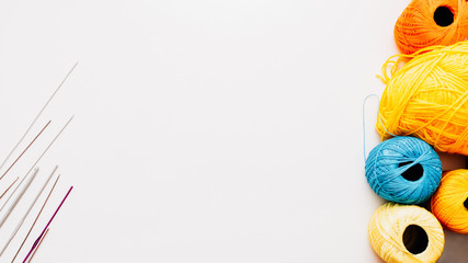 Creative handiwork. Knitting hobby leisure. Yellow blue threads crochet hooks on white background.