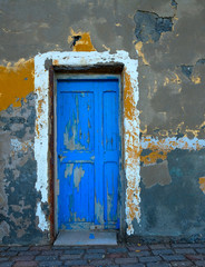 Old wooden blue painted door in a wall of an old fishing house.