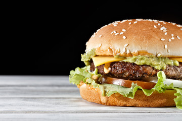Single beef patty tasty burger flavored with avocado and melted cheese garnished with tomatoes, fresh lettuce and white onions. Perfect for fulfilling your delivery cravings.