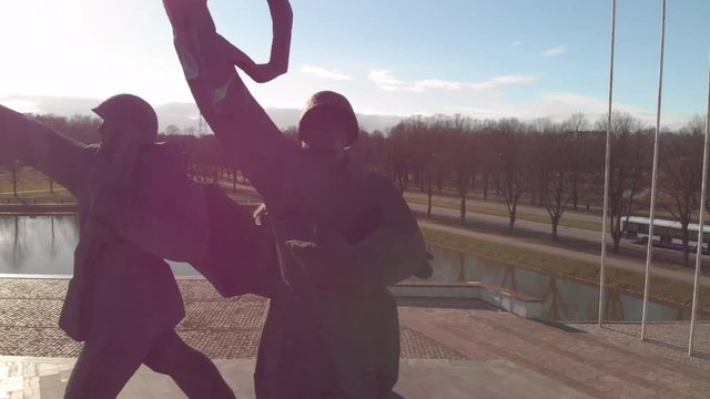 Aerial view around Victory monument (soldiers with raised riffle and hands) on sunny day in Riga. Soviet architecture after World War 2