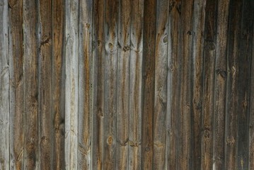 Naklejka premium dark wooden texture of gray and brown boards in the wall of the fence on the street