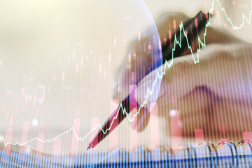 Abstract creative financial graph with world map and with woman hand writing in diary on background, financial and trading concept. Multiexposure